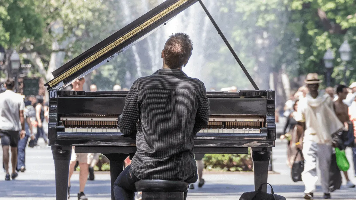 A pianist performing outdoors in a busy city park, capturing the vibrant live music scene and street culture.