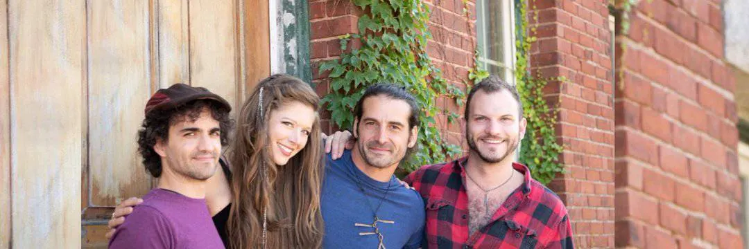 Smiling diverse group of friends outdoors against brick wall enjoying each other's company.