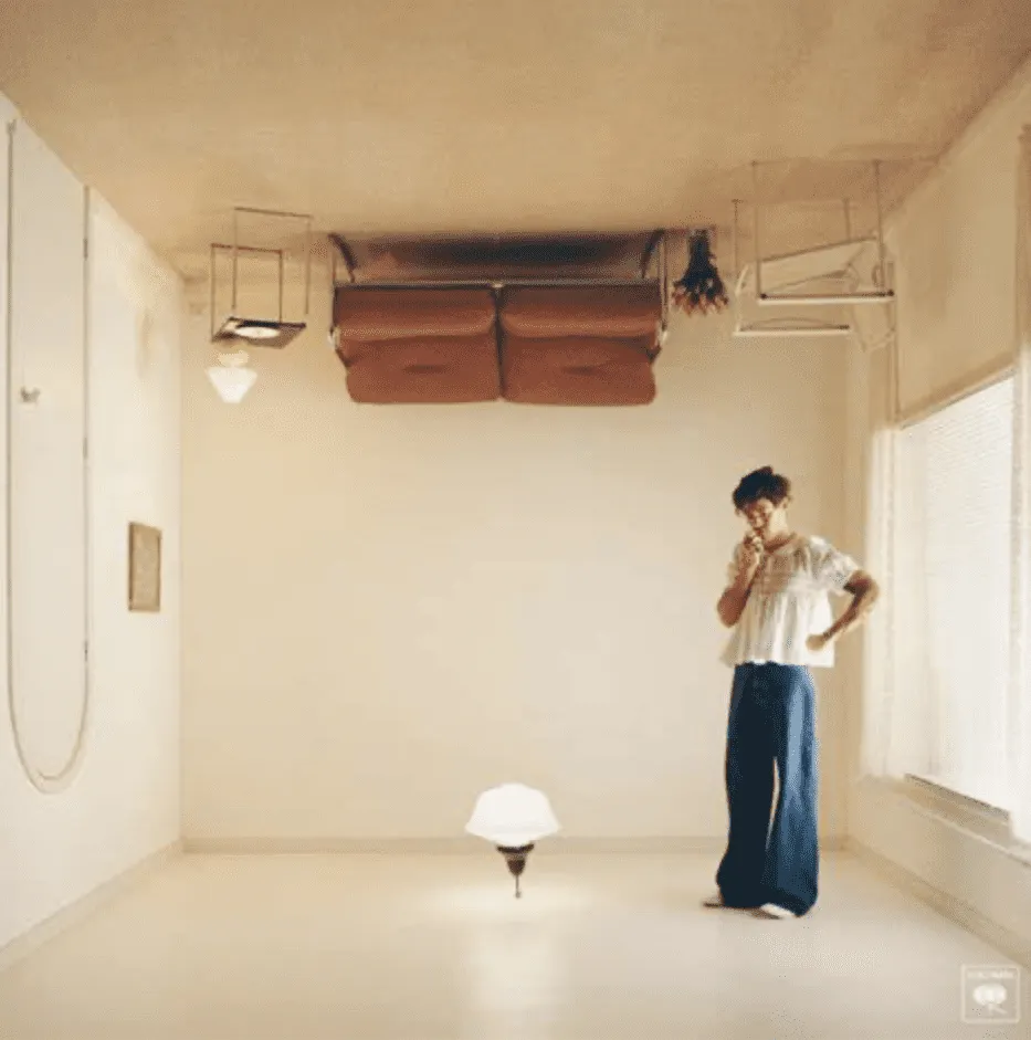 Upside-down room with a woman standing and contemplating, featuring modern decor, large windows, and minimalist design elemen
