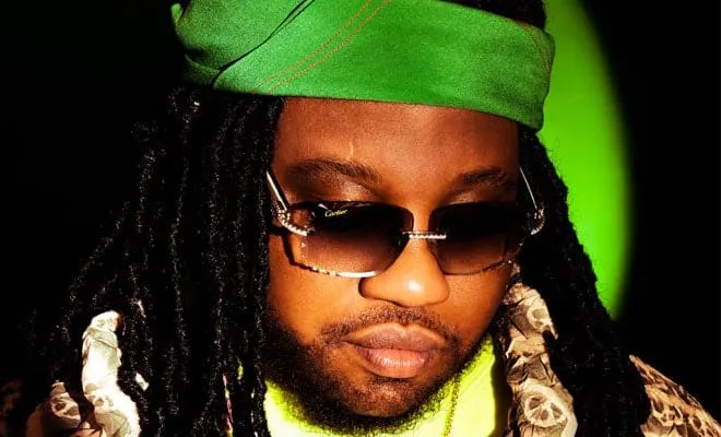 Hypebot musician artist with sunglasses and green headscarf at music industry event 2023.