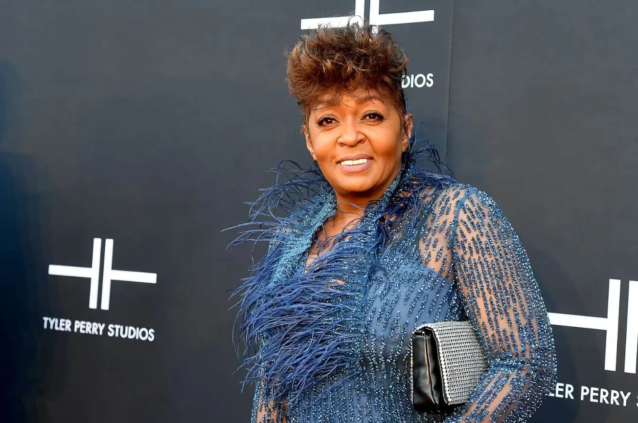 Elegant woman in a glamorous blue dress with feather details attending a Tyler Perry Studios event, showcasing celebrity fash