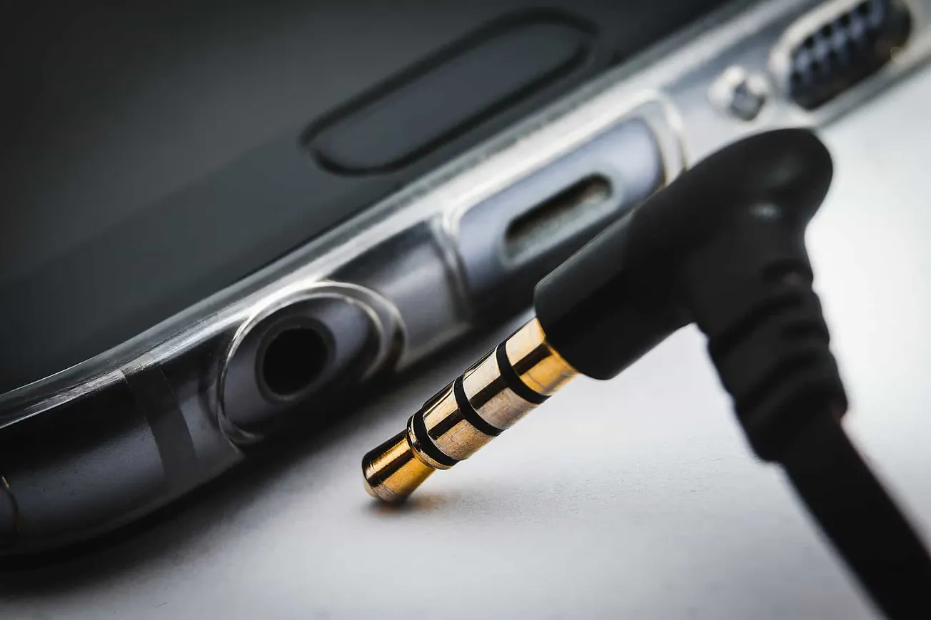 Close-up of a 3.5mm headphone jack plugged into a device, highlighting audio connection technology and portable music accesso