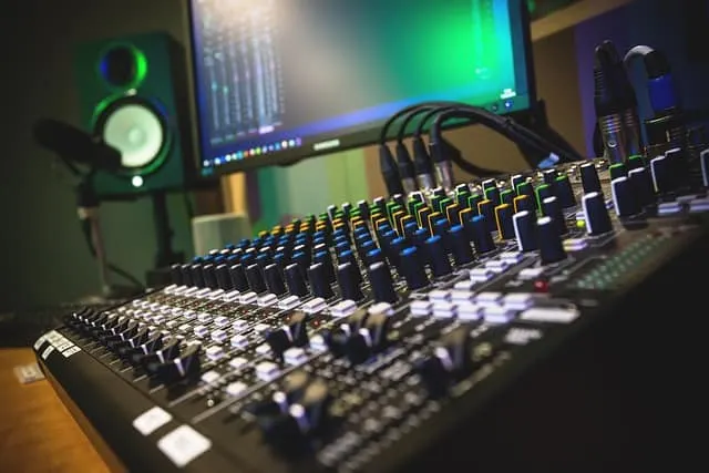 Studio mixing console with digital audio workstation setup for music production, recording, and sound engineering in a profes