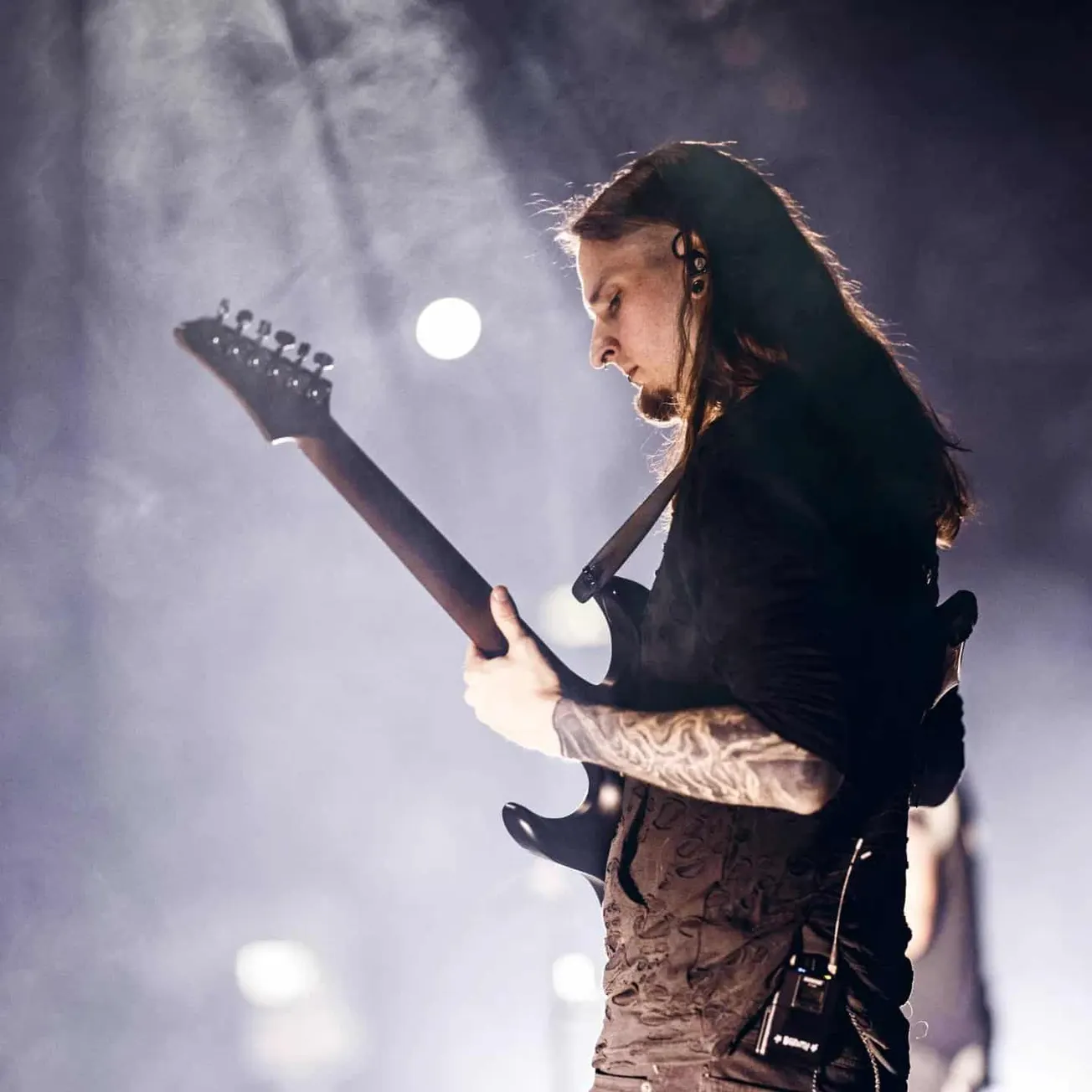 Energetic guitarist performing on stage during live music concert, showcasing talent and passion in rock or metal genre, with