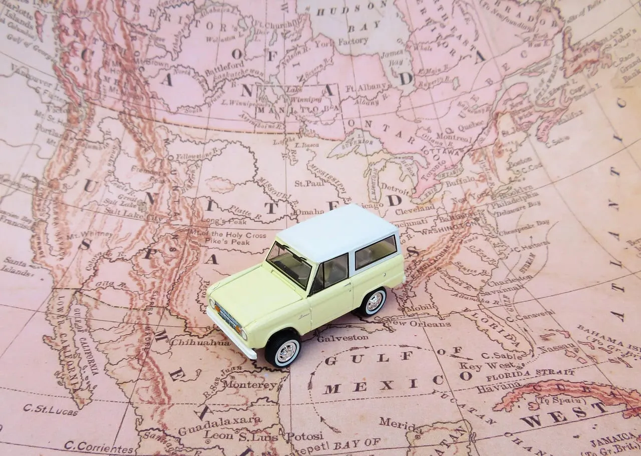 High-quality miniature car model on vintage map, travel inspiration, car travel, exploration, adventure, world map background