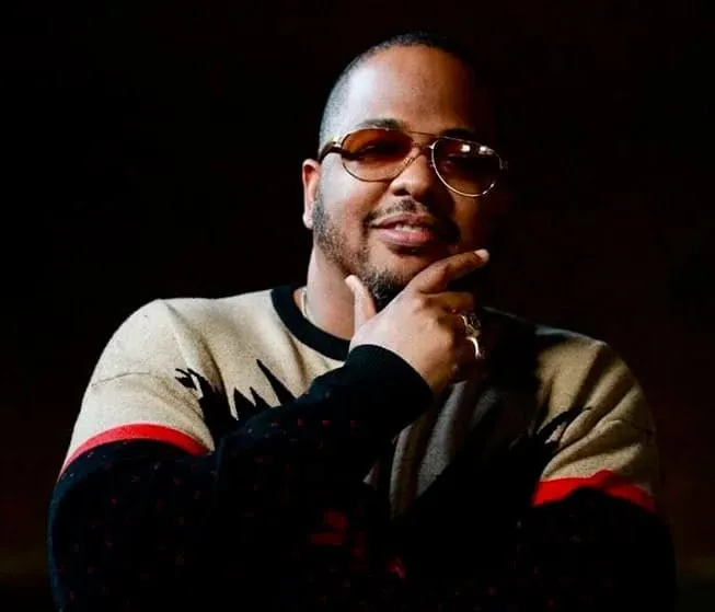 Someone thinking creatively, wearing sunglasses and a casual sweater, with a confident expression, symbolizing innovative ide