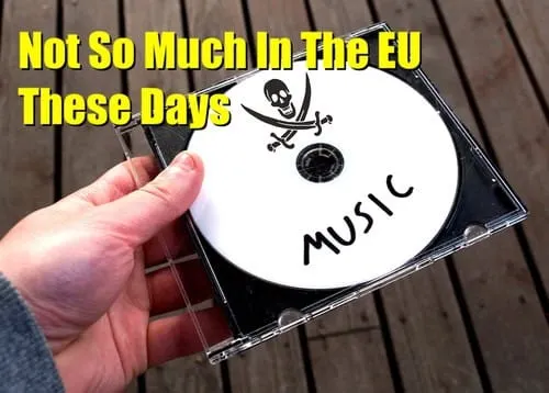 CD with skull and crossbones graphic labeled "MUSIC," held over wooden surface.