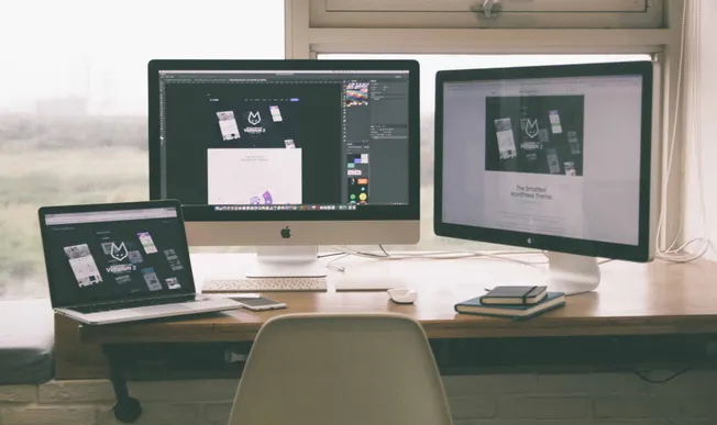 High-tech music and graphic design setup with multiple monitors, laptop, and creative tools, representing digital content cre