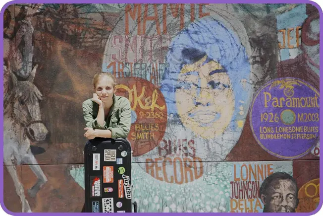 Travel expert, woman with suitcase standing in front of colorful blues and jazz music mural, vibrant street art celebrating b