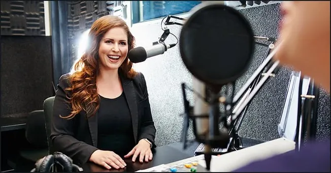 Recording a podcast interview with a female host in a professional radio studio for music, media, and entertainment industry