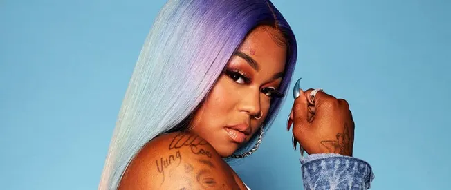 Rainbow-colored long straight hair with pastel shades, woman with tattoos and jewelry modeling for Hypebot, vibrant music and