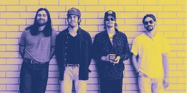 Young indie band members standing against brick wall, relaxed music scene, casual style, vibrant atmosphere, modern musicians