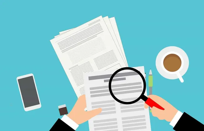 Filename: business-analysis-zooming-in-on-documents-with-magnifying-glass.jpg.