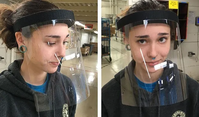 Face shield demonstration in industrial setting for safety and protection, young woman wearing protective gear, PPE equipment