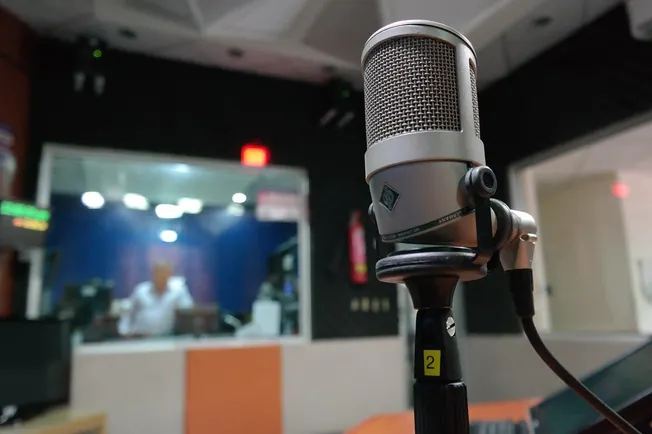 Microphone on a stand in a recording studio or radio station.