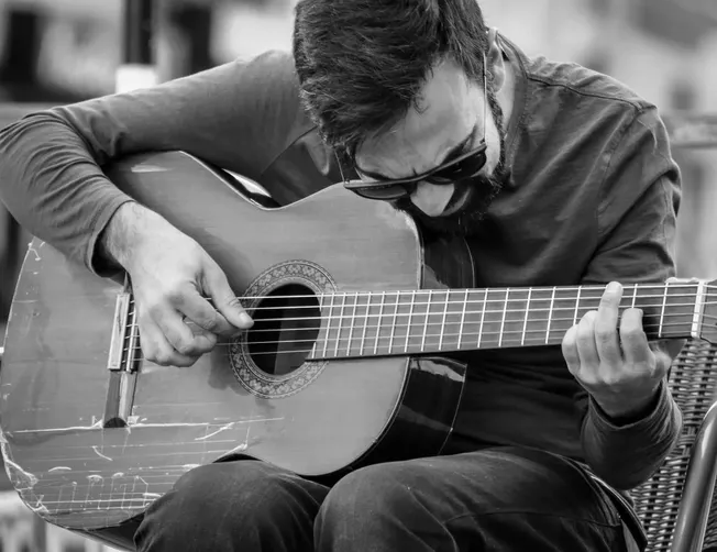 Guitarist playing acoustic guitar on street, black and white, street music, musician, solo performance, urban music scene, st