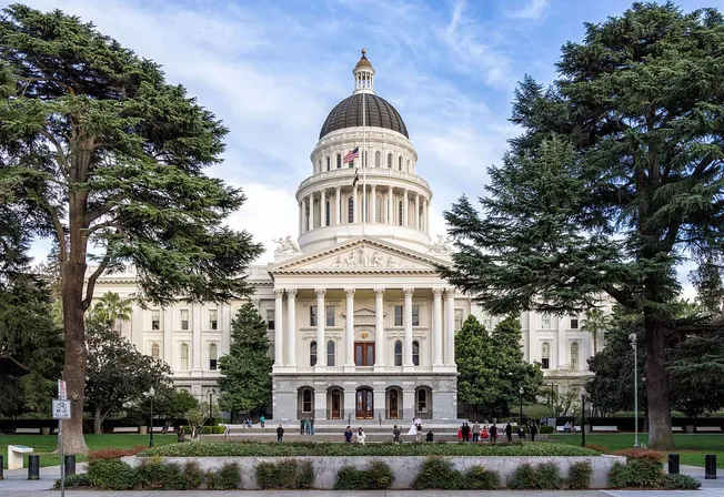 Majestic California State Capitol building in Sacramento surrounded by lush greenery, visitors enjoying the historic site, un