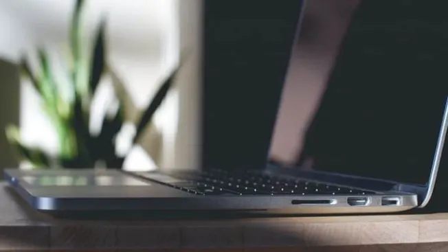 Laptop on wooden desk for music industry news and digital marketing insights.