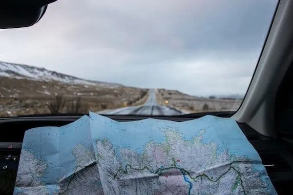Map of a road trip route on paper inside a car, travel planning, navigation, road trip preparation, adventure travel, scenic