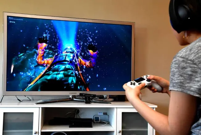 Vibrant gaming scene displayed on Samsung TV with a player using a console controller, highlighting immersive entertainment e