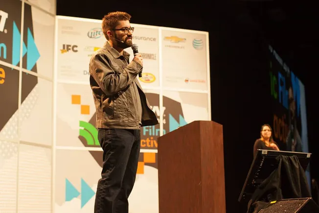 Engaged speaker at a film conference delivering a presentation on industry trends and innovations.
