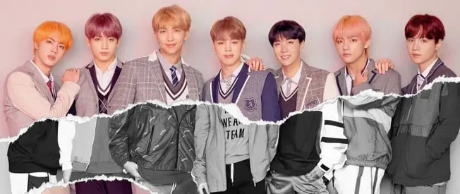 K-pop boy band members in stylish school uniform-inspired outfits, posing together for a photo representing modern music cult