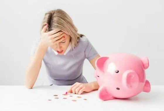 Frustrated woman worried about money with pink piggy bank, financial stress, saving money, financial hardship, financial worr