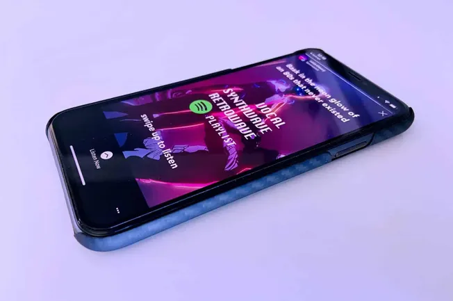 Smartphone displaying Spotify app with music, digital streaming, and entertainment keywords for SEO optimization.