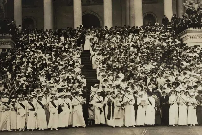 Massive crowd of people gathered on steps of government building, historic black and white photograph, early 20th-century pub