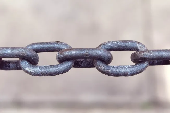 Rusted metal chain links for industry or security purposes, close-up image.