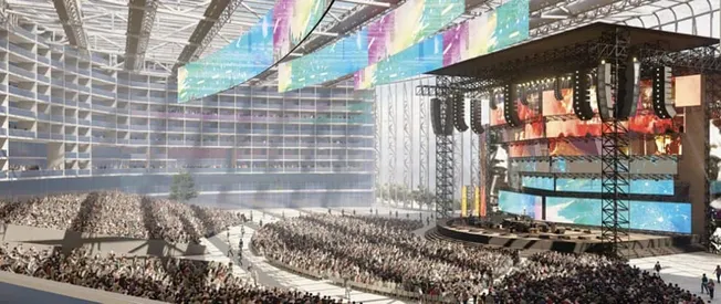Hypebot at a large music concert or festival with a massive stage, vibrant screens, and a huge crowd of music fans enjoying a