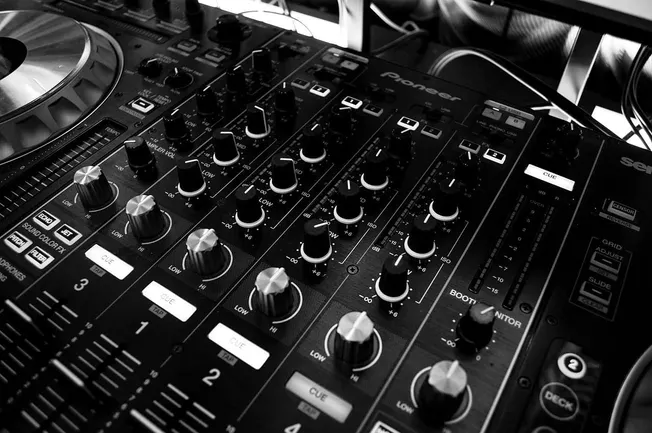 DJ mixing console with professional audio equipment, used for music production and live performances, reflecting the latest t