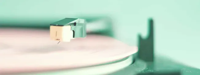 Close-up of a turntable tonearm playing a vinyl record, emphasizing music technology and audio equipment.