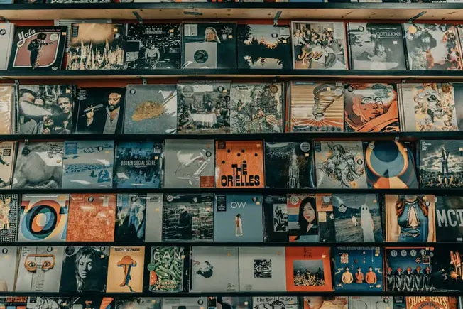 Albums displayed on store shelves showcasing diverse music records, vinyl, and album covers for music lovers and collectors,