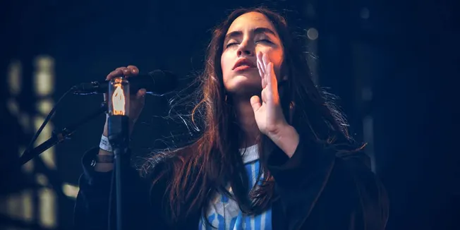 Young female singer performing passionately on stage with microphone, music artist, concert, live performance, music event, e