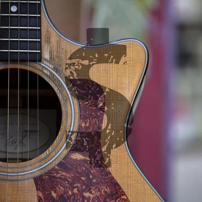 Natural wood acoustic guitar with a colorful artistic silhouette reflection on the body, music instrument showcasing craftsma