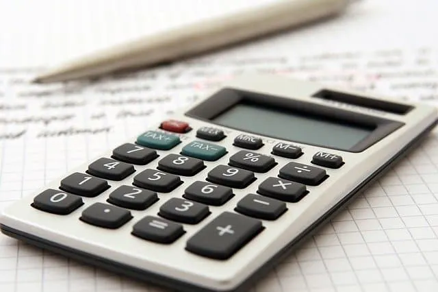 Calculator on a sheet of handwritten notes, symbolizing financial analysis or music industry calculations.