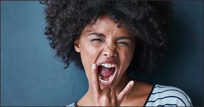 Expressive young woman shouting with frustration or excitement, showcasing strong emotion and energetic attitude, against sol