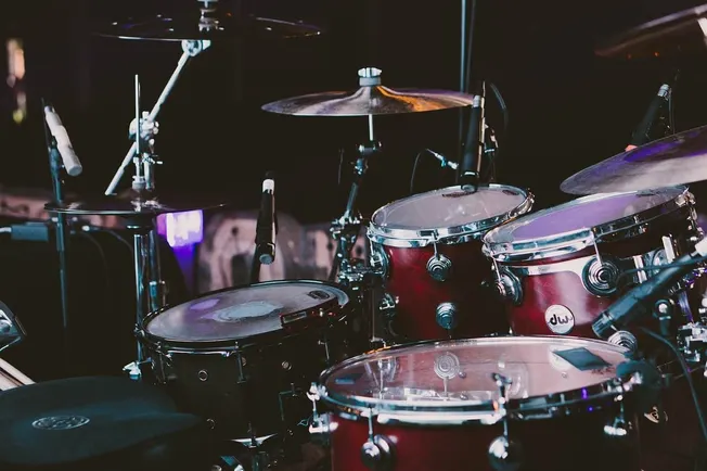 Drum set with cymbals and microphones in a music studio or stage setup.