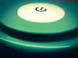 Power button illuminated on electronic device, symbolizing startup or power on.