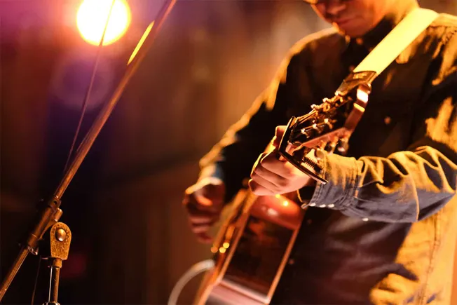 Guitarist performing live music at a concert, illuminated by stage lighting, capturing the passion and energy of a musical pe
