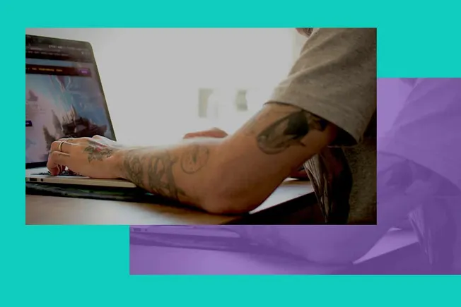 Tattooed person using laptop for music production or digital content creation, casual workspace with colorful background, Hyp