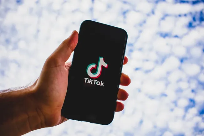 TikTok app on smartphone screen showing logo for social media marketing and content creation.