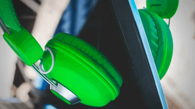 Headphones resting on a tablet, representing digital music and media consumption, with a blurred background.