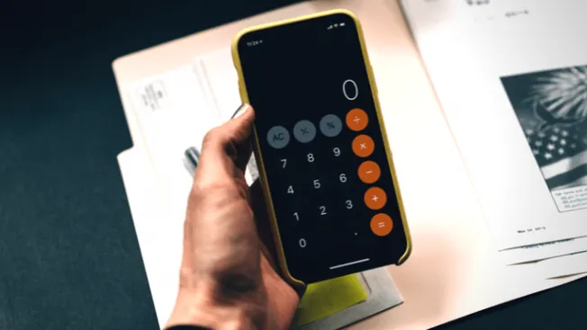 Calculator on smartphone with financial documents in background, financial analysis, business finance, digital tools for budg