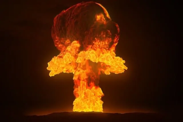 A nuclear explosion with a fiery mushroom cloud illuminated against a dark sky.