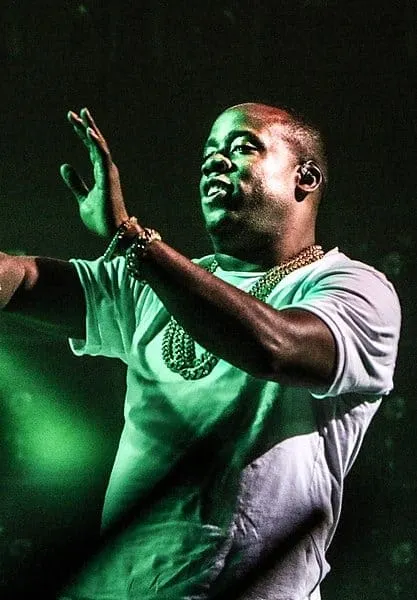 Viral rapper performing on stage under vibrant green lights, capturing the energy of live music and concert culture, perfect