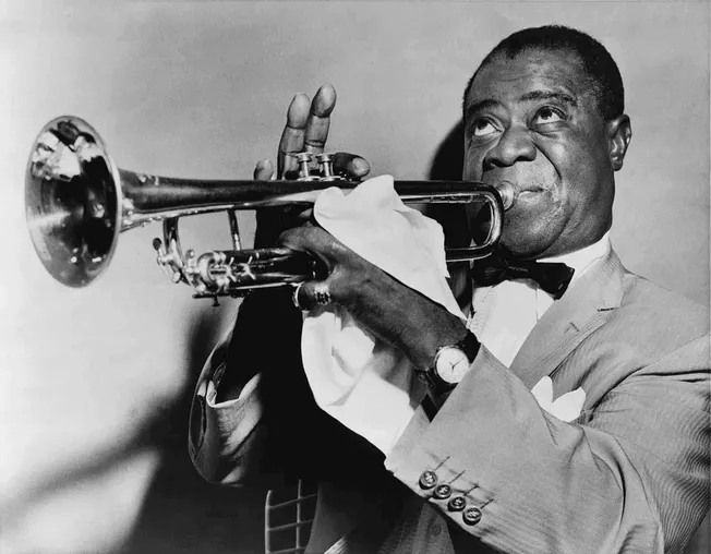 Man playing trumpet in a tuxedo, black and white photo, jazz musician, classic music performance, vintage setting, famous jaz