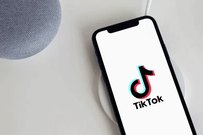 TikTok app on a smartphone placed on a wireless charging pad, showcasing the popular social media platform for short videos,