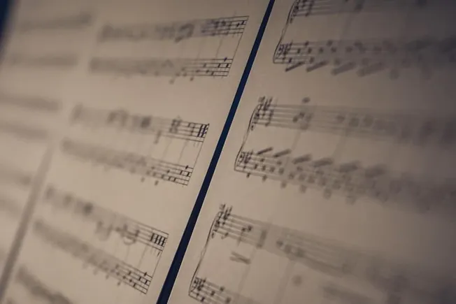 Vintage sheet music with musical notes and notation, close-up view, for music industry articles, music trends, and digital mu